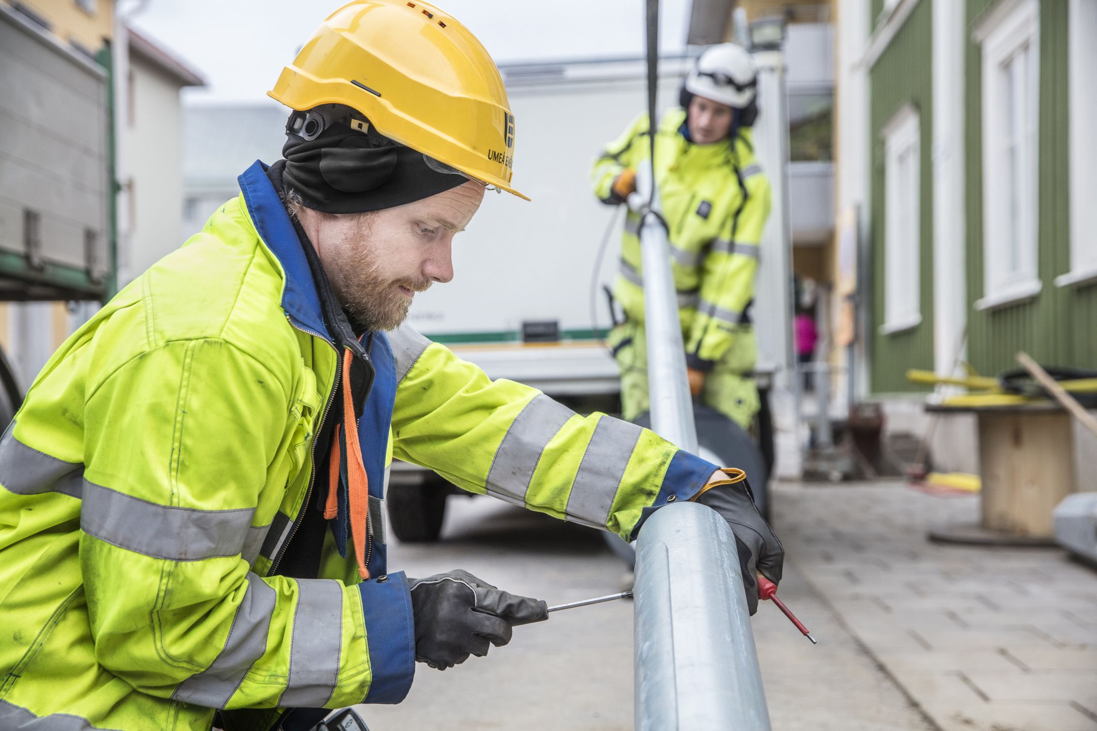 Anställd som skruvar i lyktstolpe