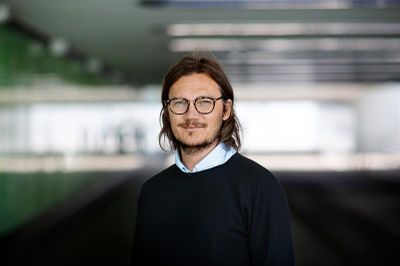 Person som tittar in i kameran med Svingen i Umeå som bakgrund.