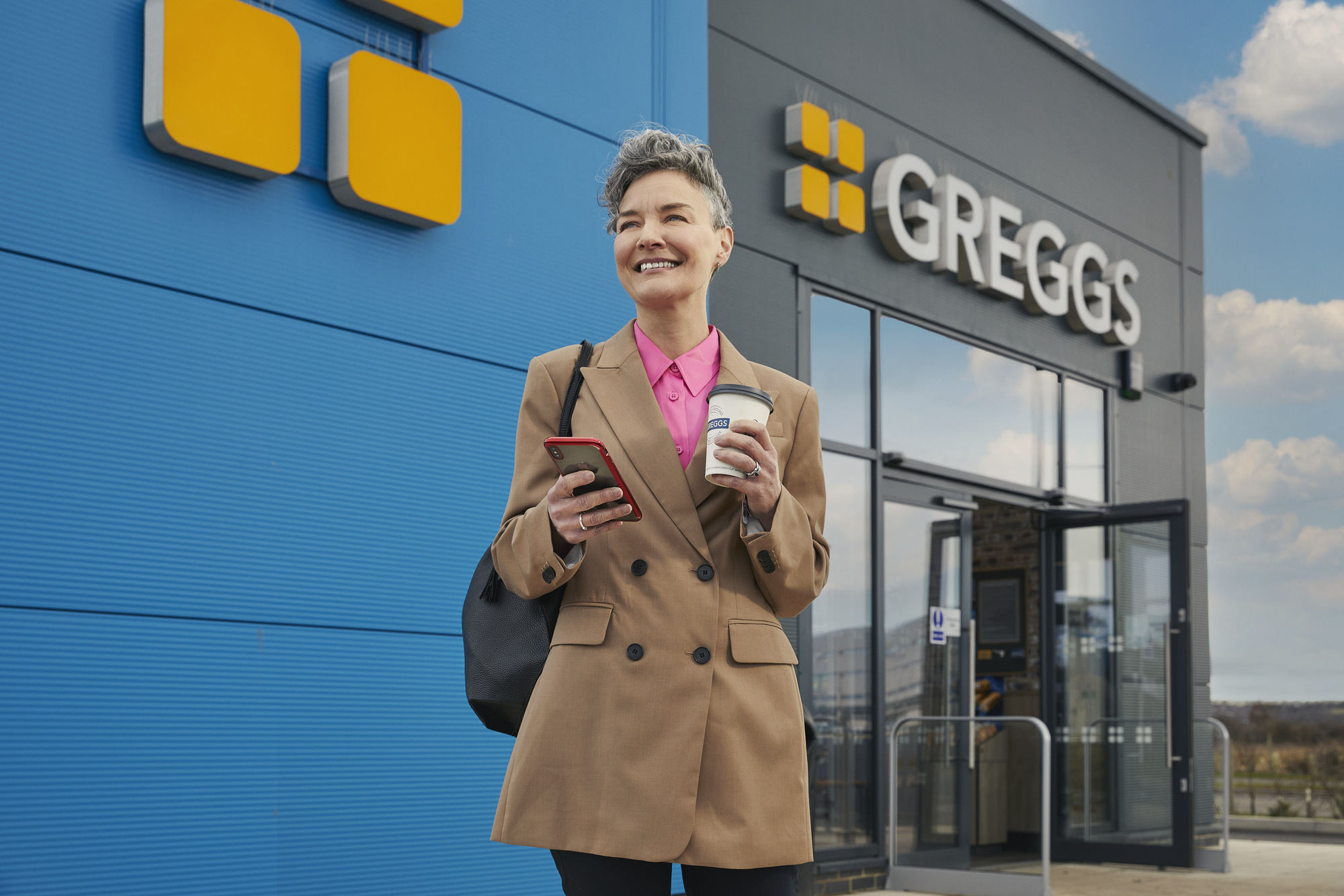 customer with coffee outside shop