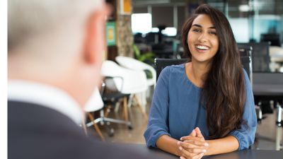 Woman sitting at desk across man who is interviewing her