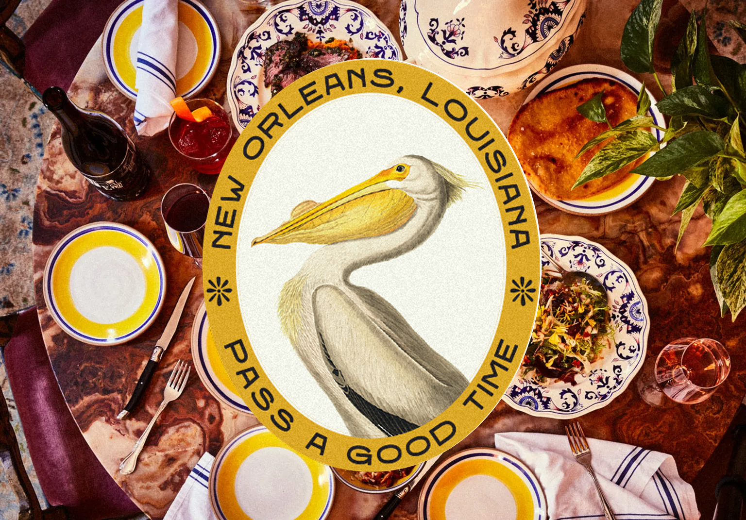 A festive dining table with colorful plates, drinks, and food, overlaid with a pelican emblem labeled "New Orleans, Louisiana, Pass a Good Time."