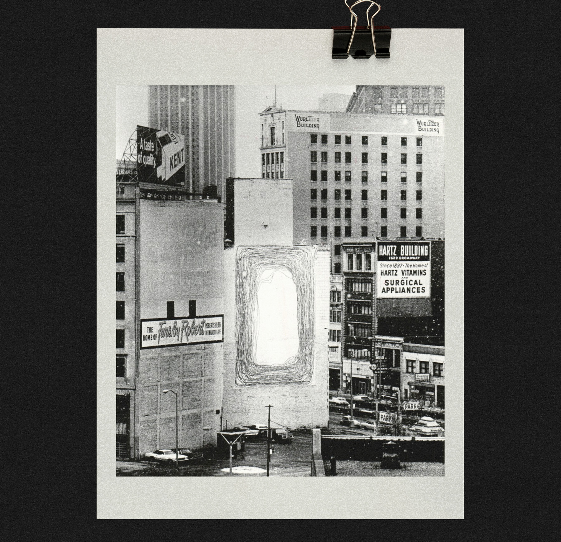 Black and white photo of a city scene with buildings featuring vintage advertisements. A highlighted art piece is displayed on one wall.