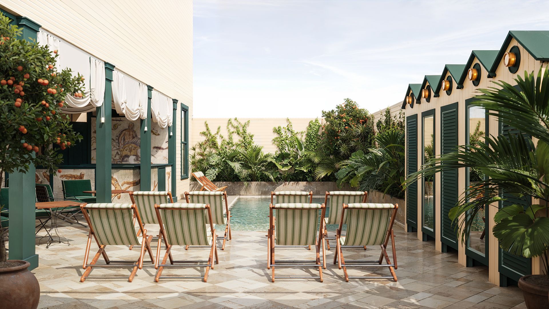 Outdoor patio with striped deck chairs facing a pool, surrounded by lush greenery and a building with green shutters and decorative awnings.
