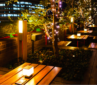 Outdoor dining area with wooden tables and soft lighting.