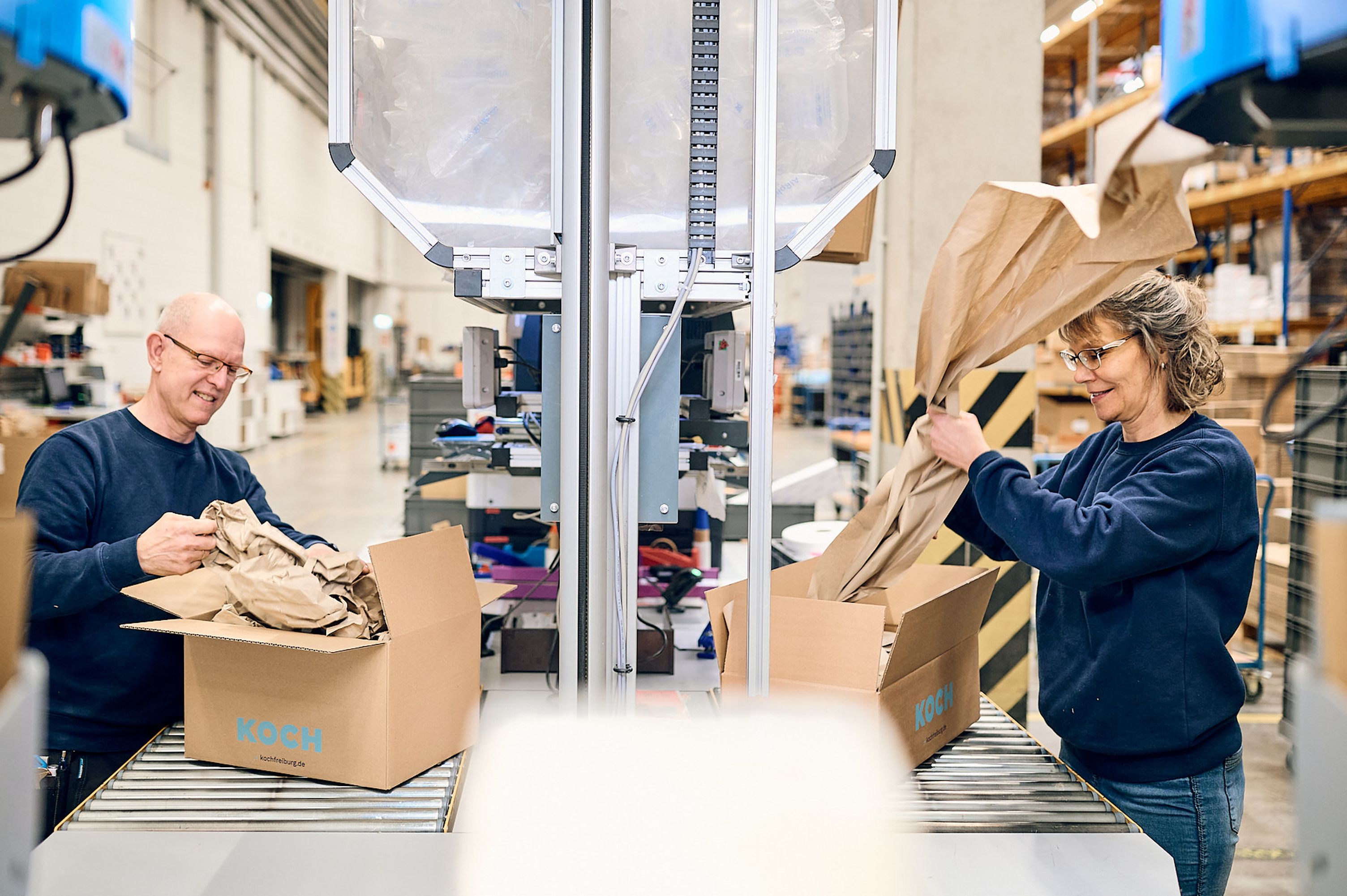Mitarbeitende am Packtisch in der KOCH-Logistik Mitarbeitende am Packtisch in der KOCH-Logistik