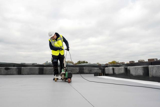 Roofer adding a tpo membrane to a roof