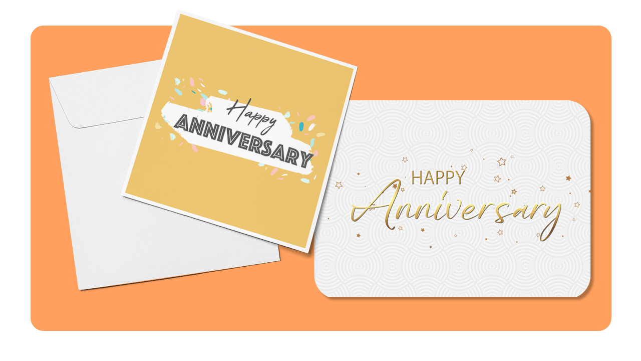 Two "Happy Anniversary" cards, one with a yellow background and confetti, the other white with gold script, placed on an orange surface.