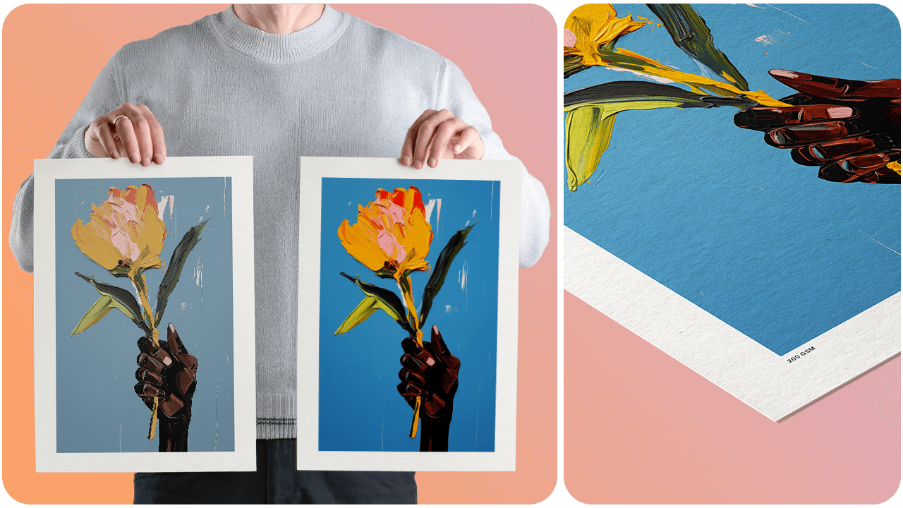 Person holding two art prints of a hand with a flower on a blue background; close-up shows textured paper and artist's signature.