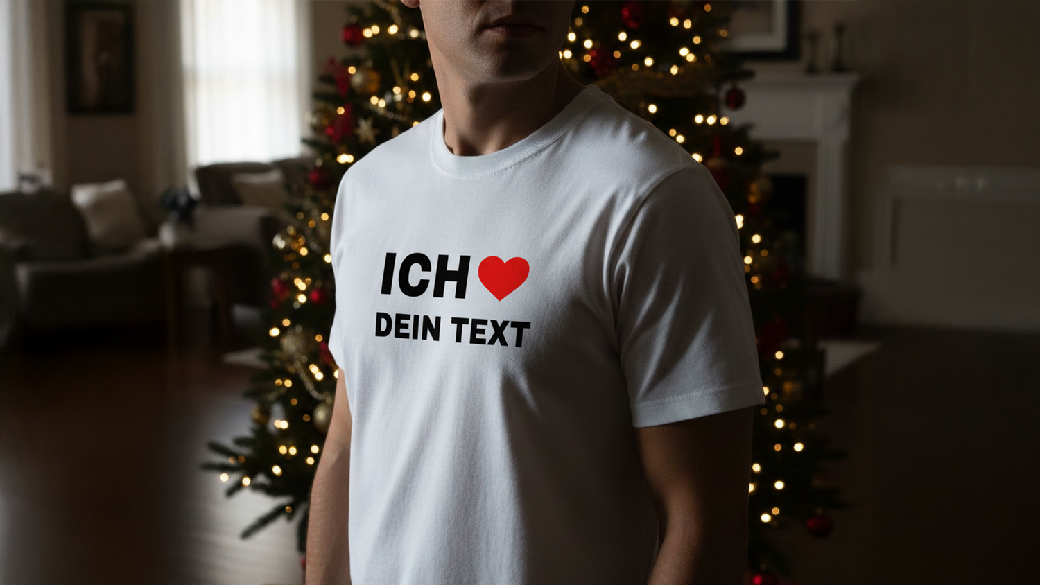 Person wearing a white T-shirt with "ICH ❤️ DEIN TEXT" stands near a decorated Christmas tree in a cozy living room.
