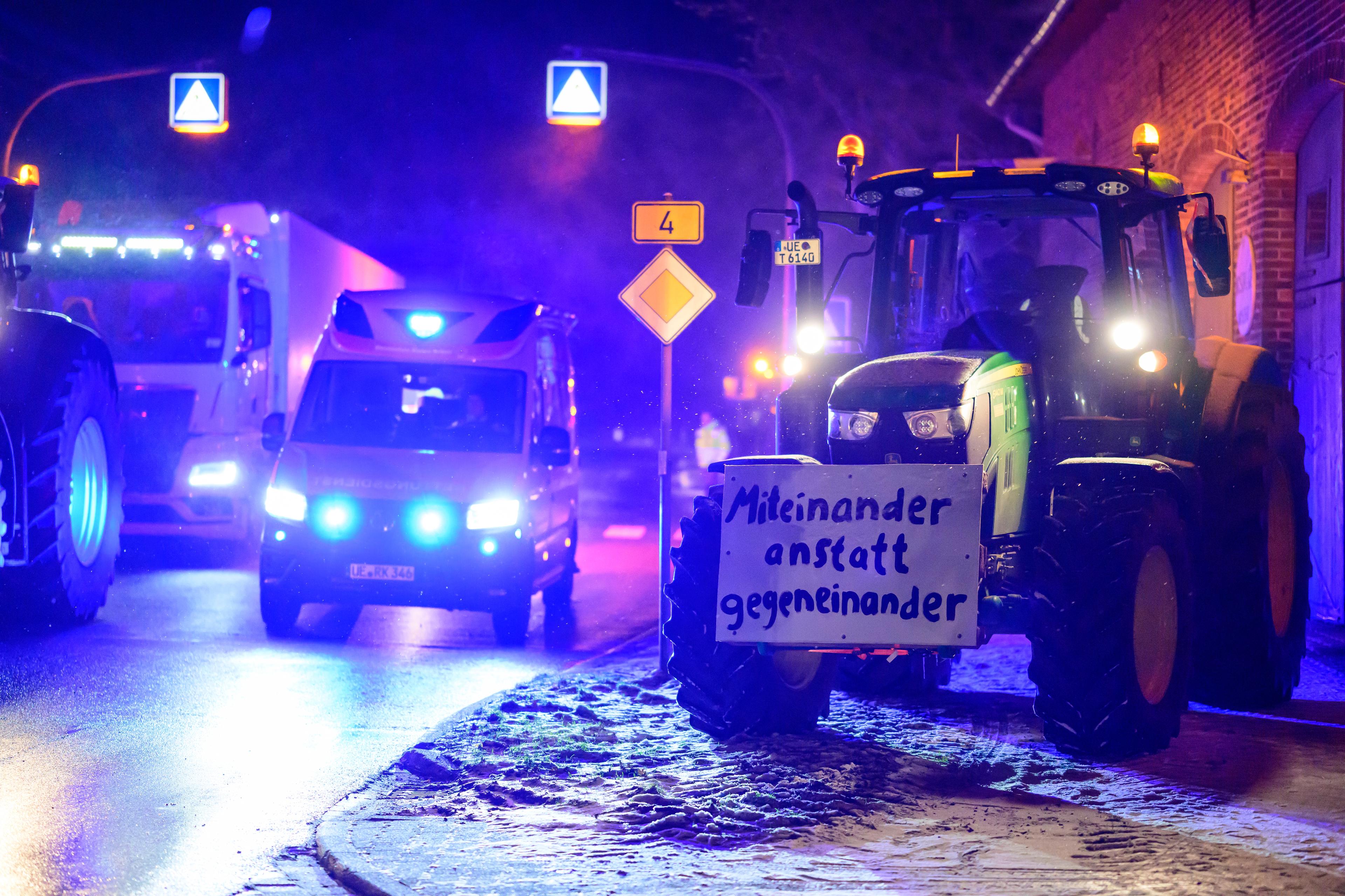 Ein Rettungswagen fährt mit Blaulicht vorbei an stehenden Treckern und Lkws. Als Reaktion auf die Sparpläne der Bundesregierung hat der Bauernverband zu einer Aktionswoche mit Kundgebungen und Sternfahrten ab dem 8. Januar aufgerufen. Sie soll am 15. Januar in einer Großdemonstration in der Hauptstadt gipfeln.