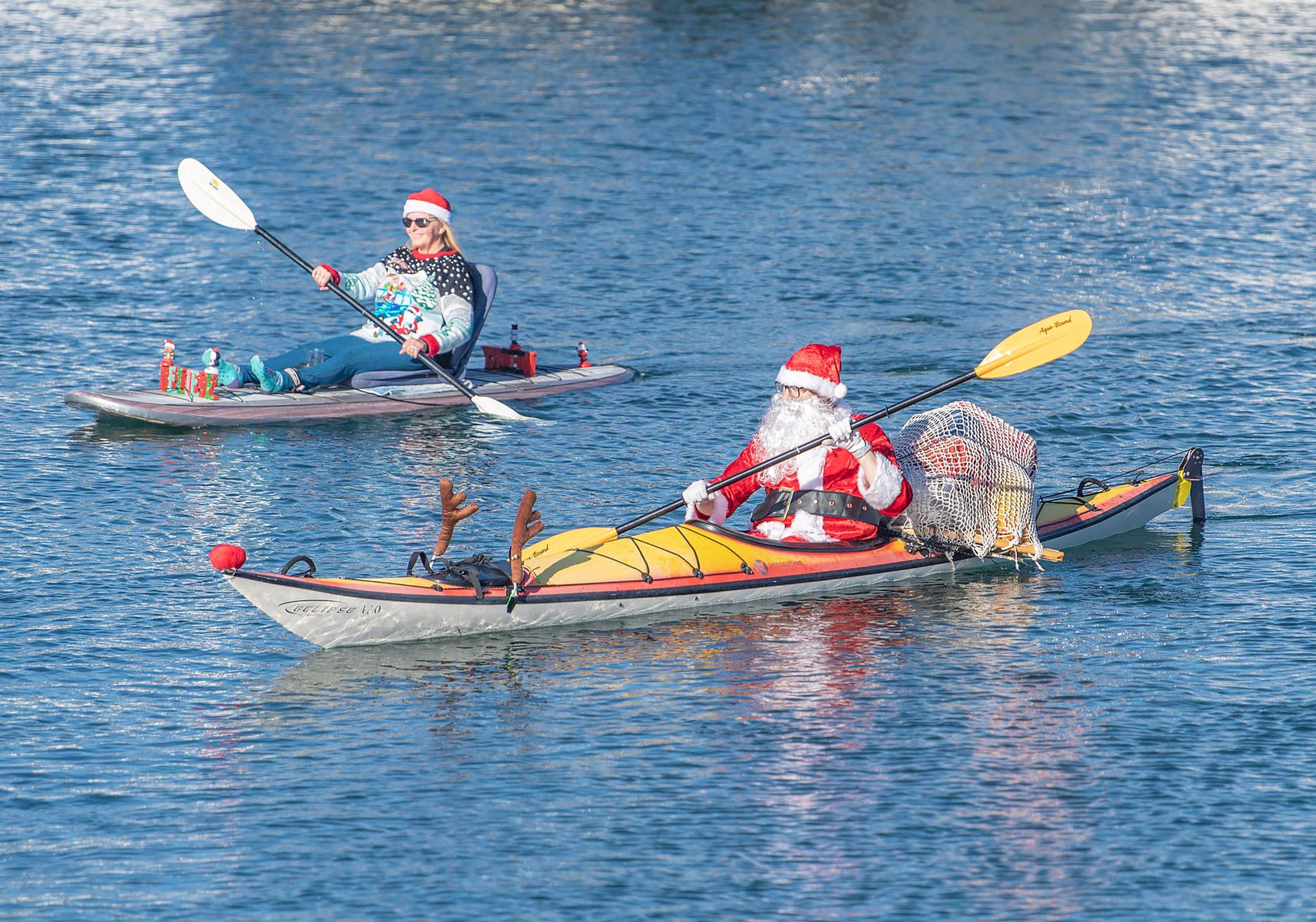 Weihnachtsmänner in Kajaks nehmen an der 39. jährlichen Lichterparade im Hafen von Santa Barbara teil.