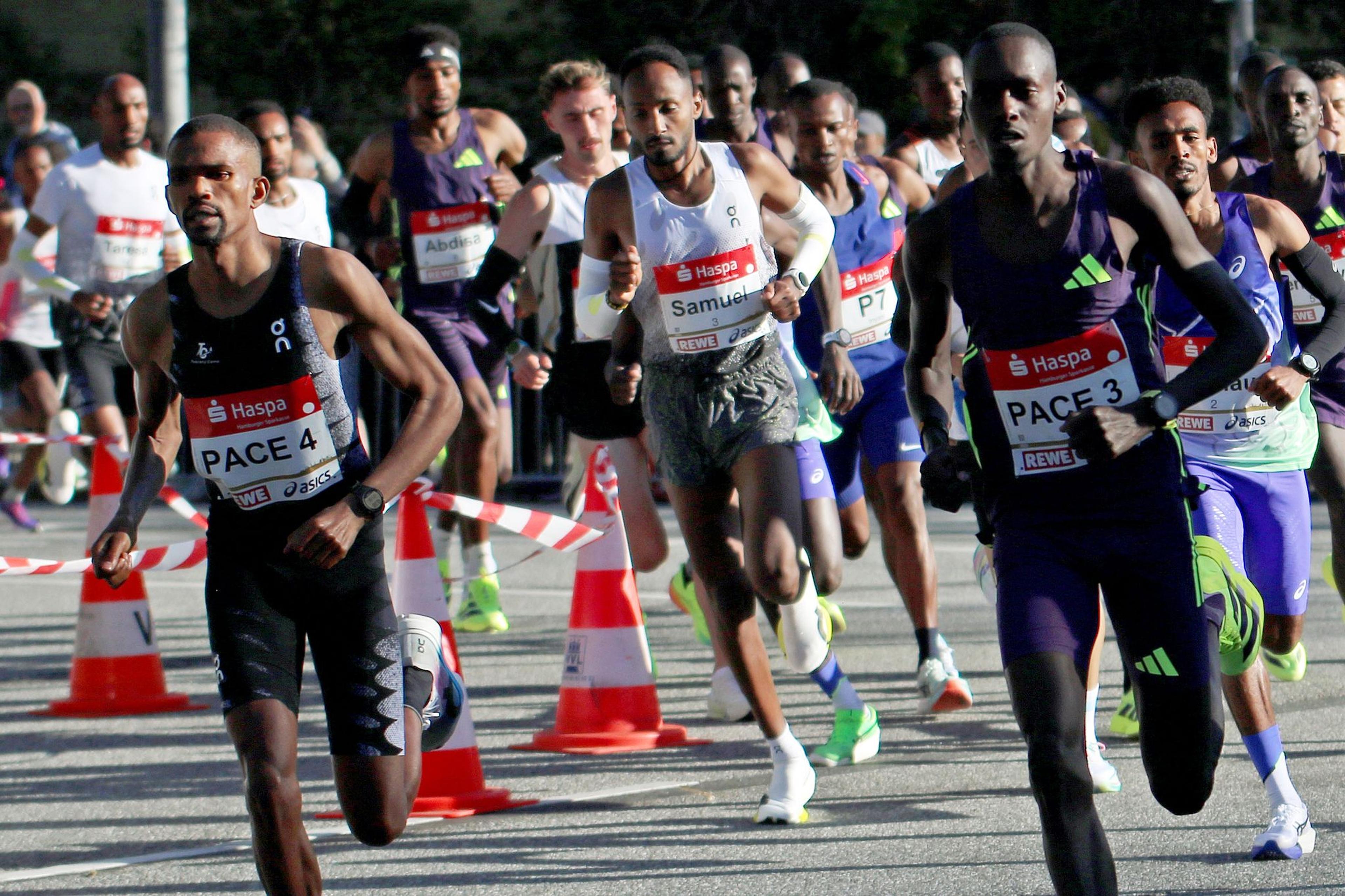 Das Elitefeld der Männer mit dem deutschen Topläufer Samuel Fitwi (M) beim 40. Haspa Marathon kurz nach dem Start auf Stecke in Aktion.