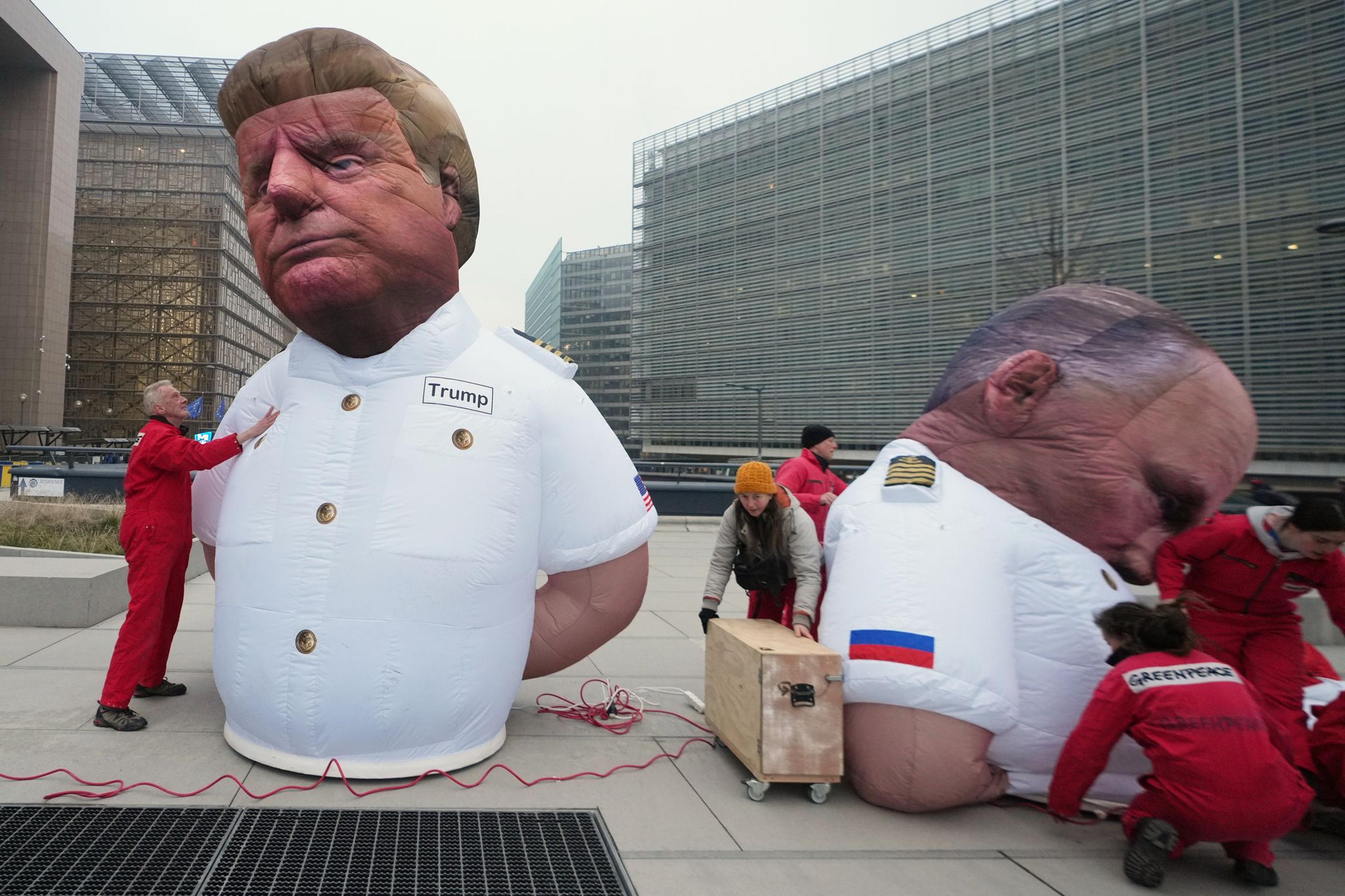 Aktivisten der Umweltorganisation Greenpeace bereiten aufblasbare Figuren vor, die den US-Präsidenten Donald Trump (l) und den russischen Präsidenten Wladimir Putin darstellen. Sie protestieren gegen die Abhängigkeit Europas von Gasimporten aus den USA und Russland vor dem EU-Hauptquartier in Brüssel.