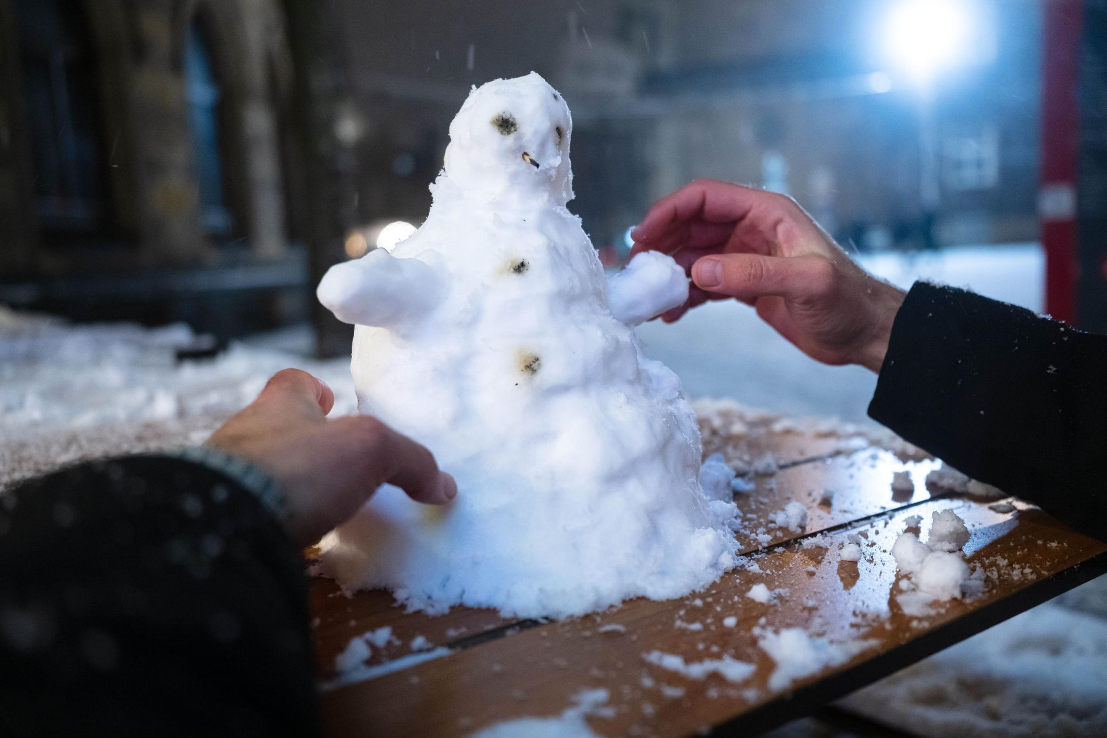 Ein kleiner Schneemann wird in der Bremer Innenstadt gebaut.