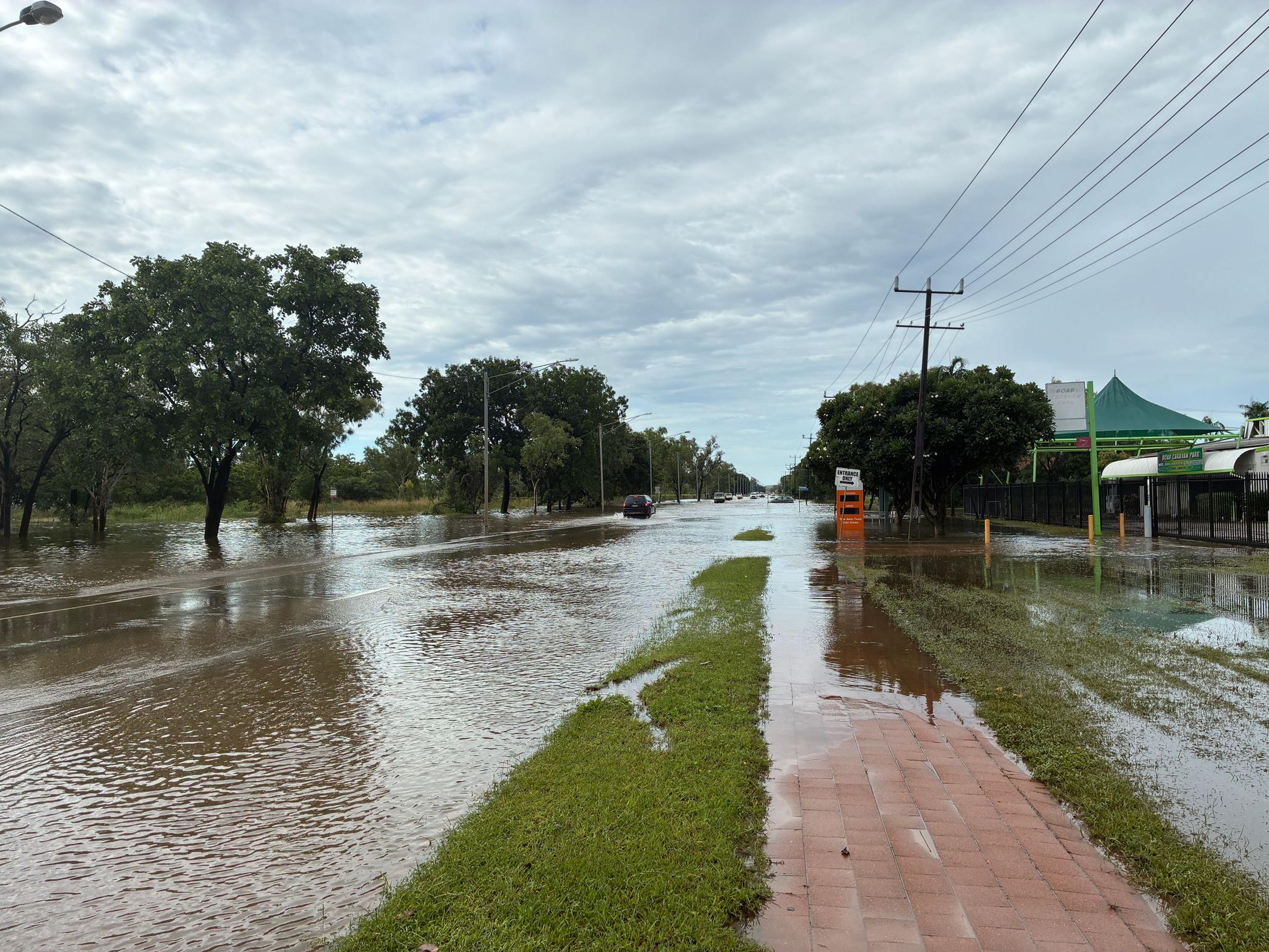 Fahrzeuge fahren durch überflutete Straßen in Katherine South, Northern Territory, Australien.