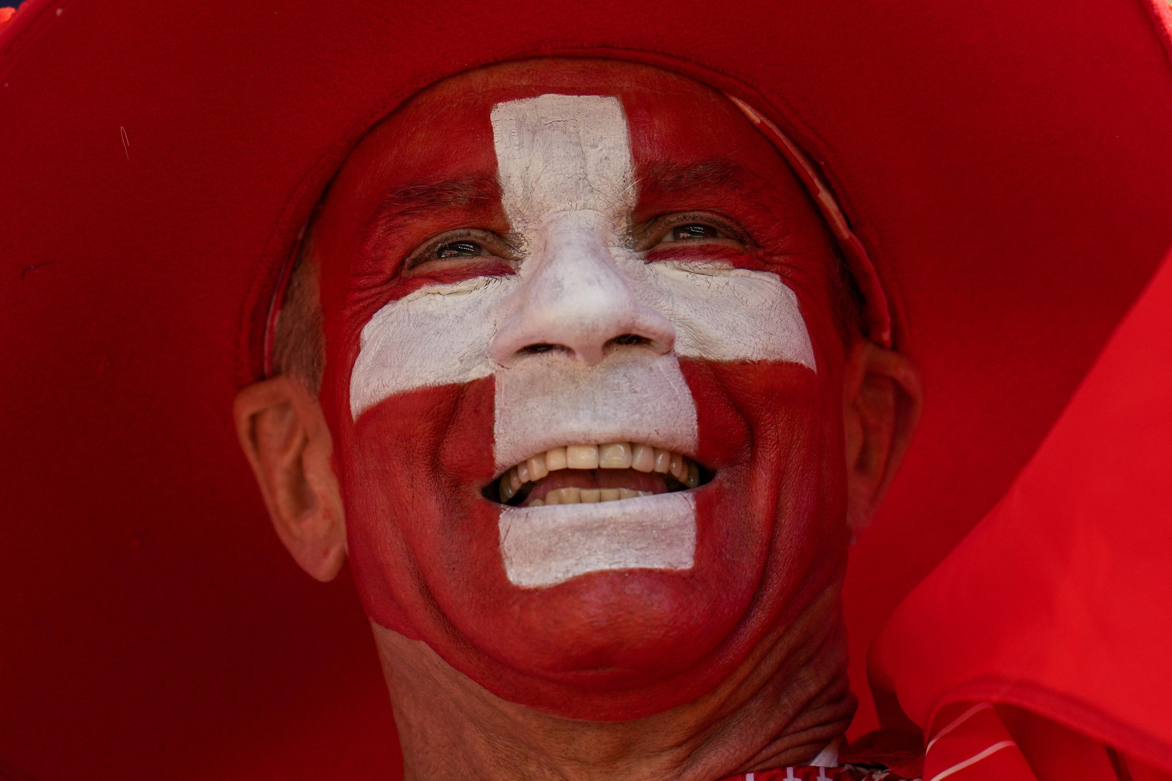 Schweizer Fußball-Fan mit aufgemalter Flagge im Gesicht