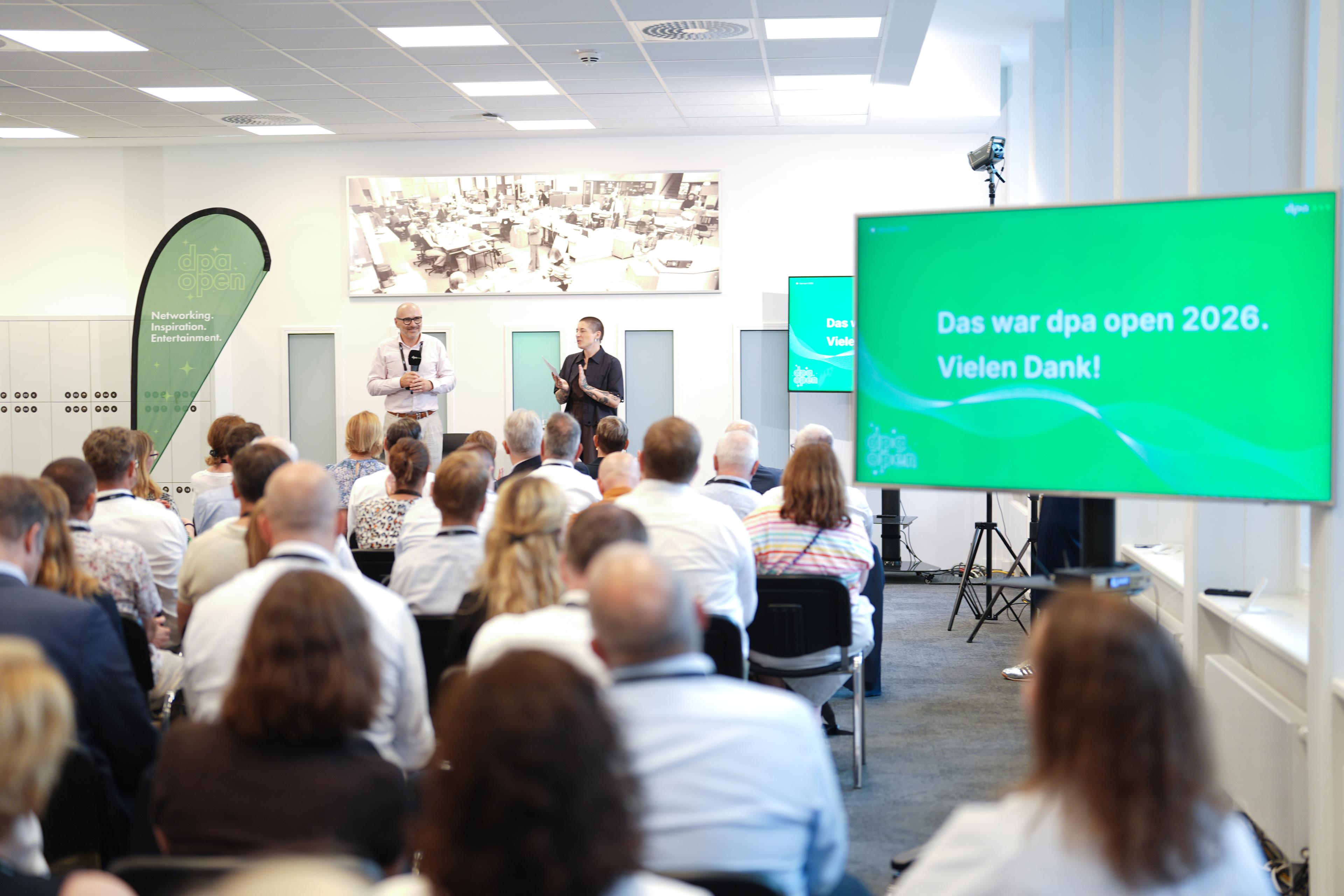 Zuhörer, die in einem Konferenzraum einem Vortrag lauschen; auf einer Leinwand steht: „Das war dpa open 2026. Vielen Dank!“