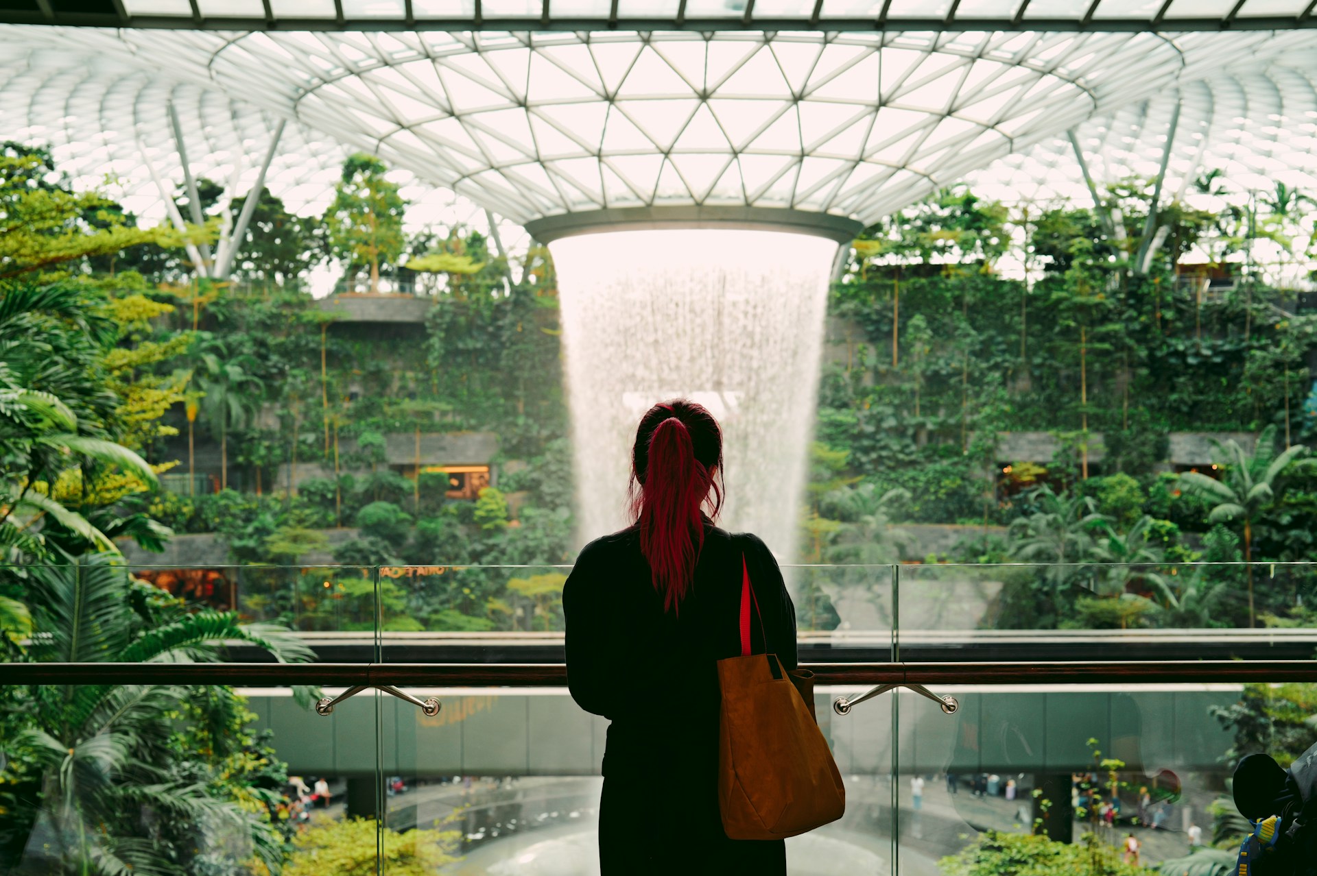 Mulher admira cascata artificial dentro do shopping center