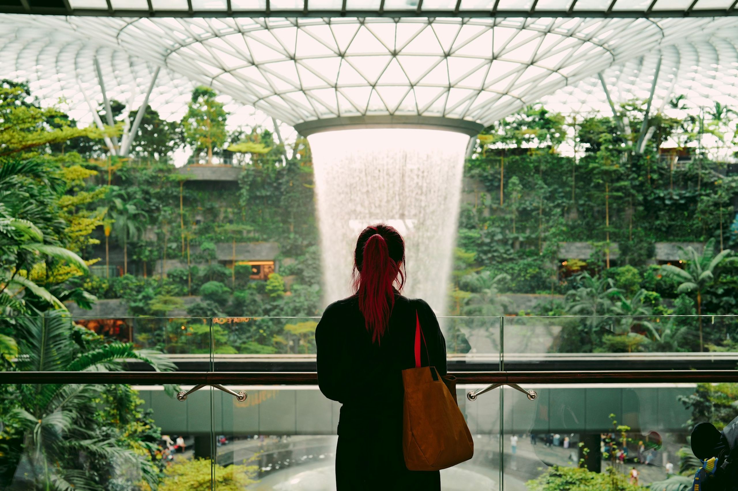 Mulher admira cascata artificial dentro do shopping center
