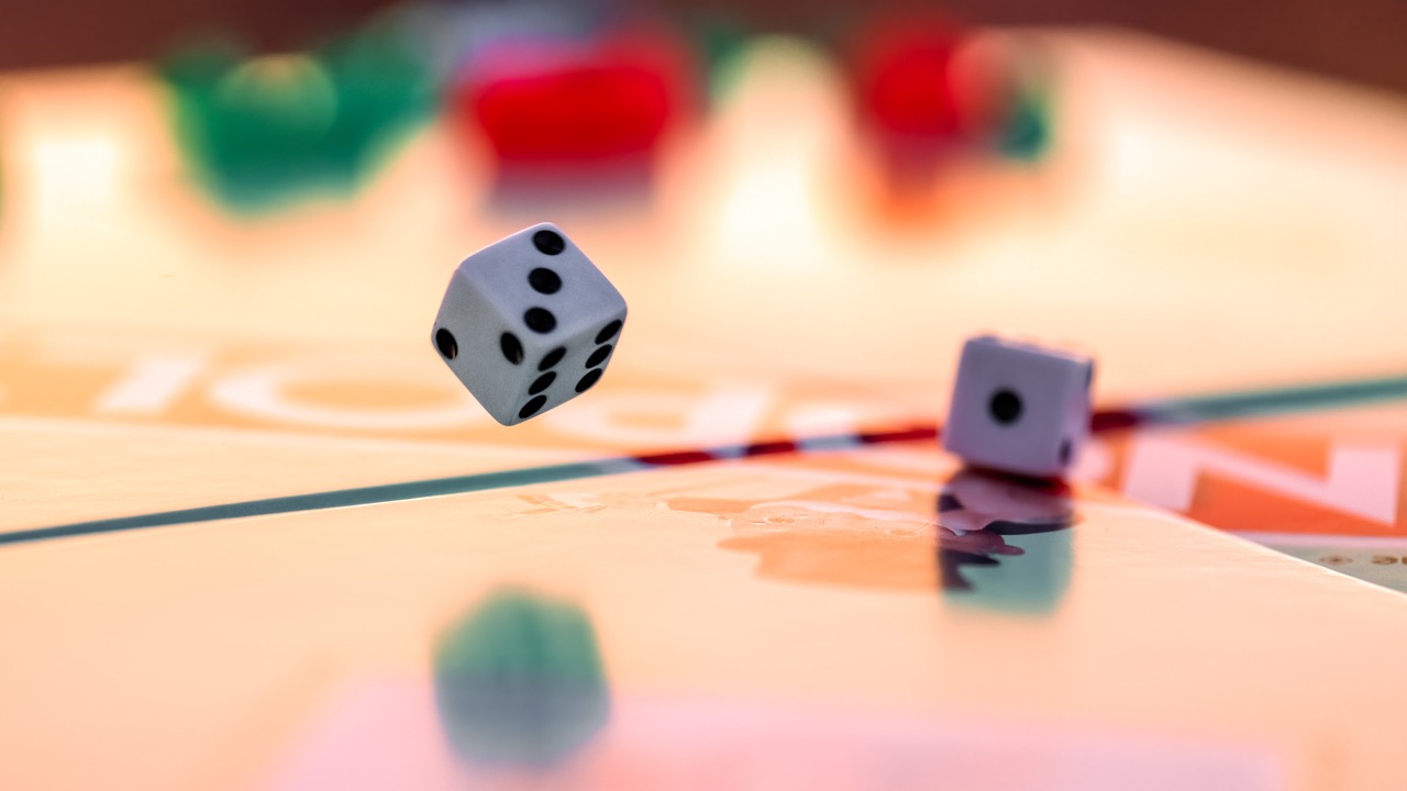 Twee dobbelstenen bewegen op een bordspel van Monopoly