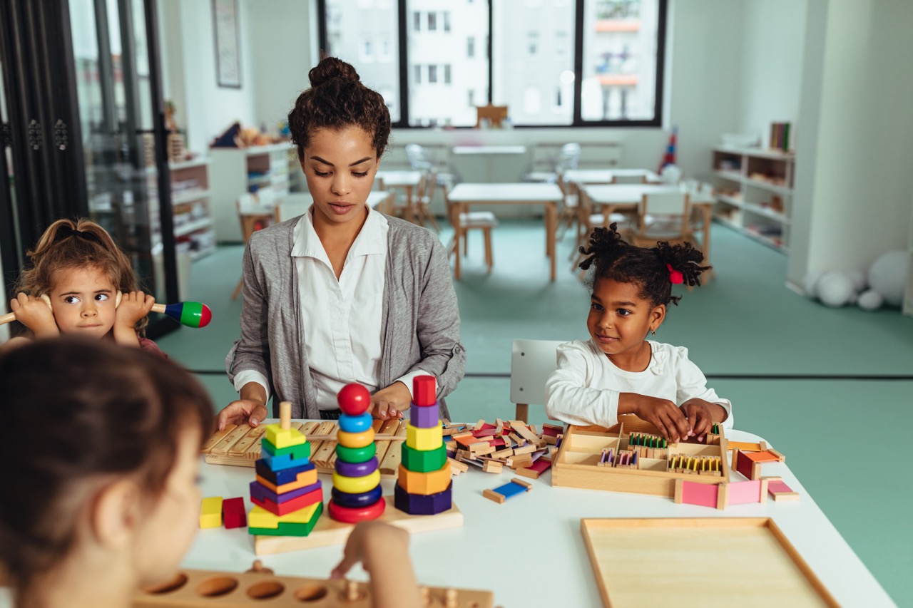 Juf speelt met kinderen in de klas of de opvang