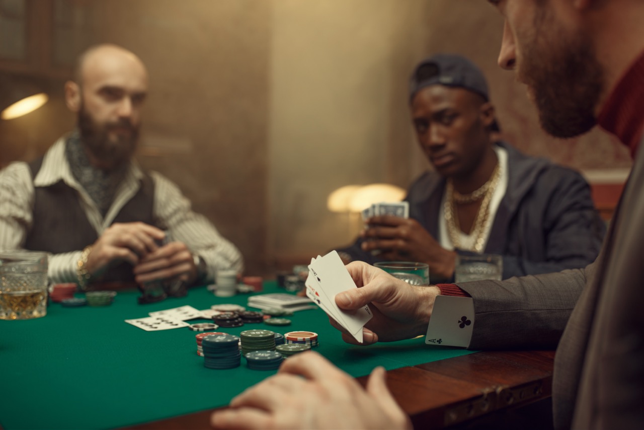Man speelt vals bij poker en heeft een kaart in zijn mouw