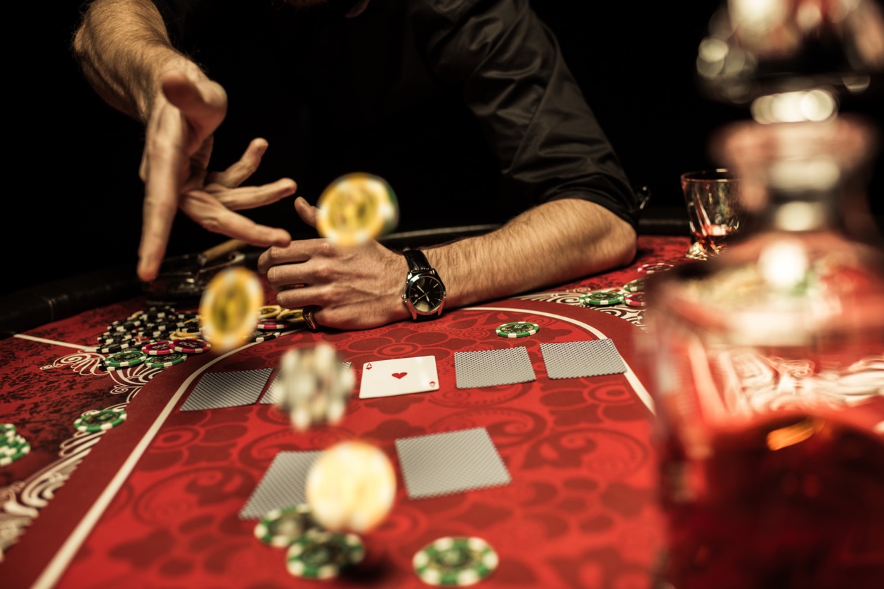 Man gooit chips op tafel bij een spelletje poker