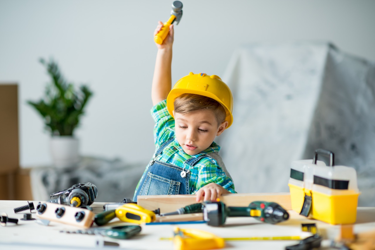 Kleine jongen met helm en speelgoedgereedschap