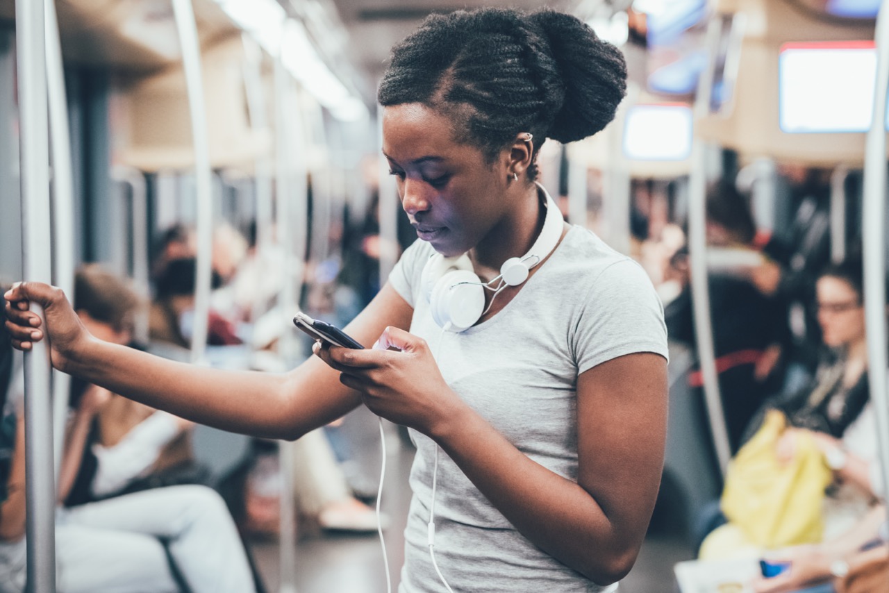 Vrouw suft op smartphone in de metro