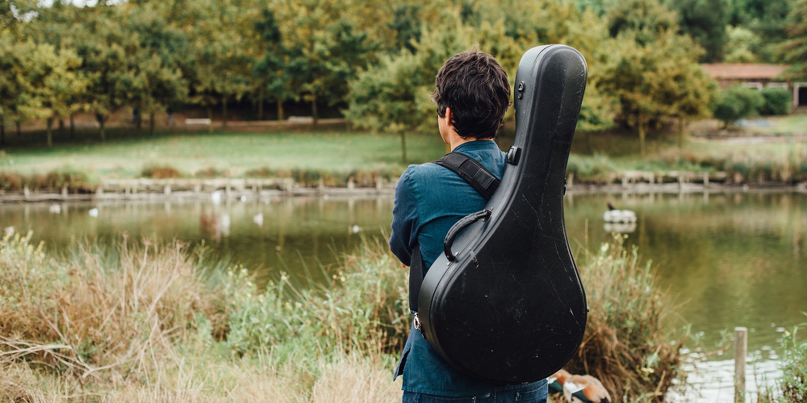 Mann mit Instrumentenkoffer auf dem Rücken