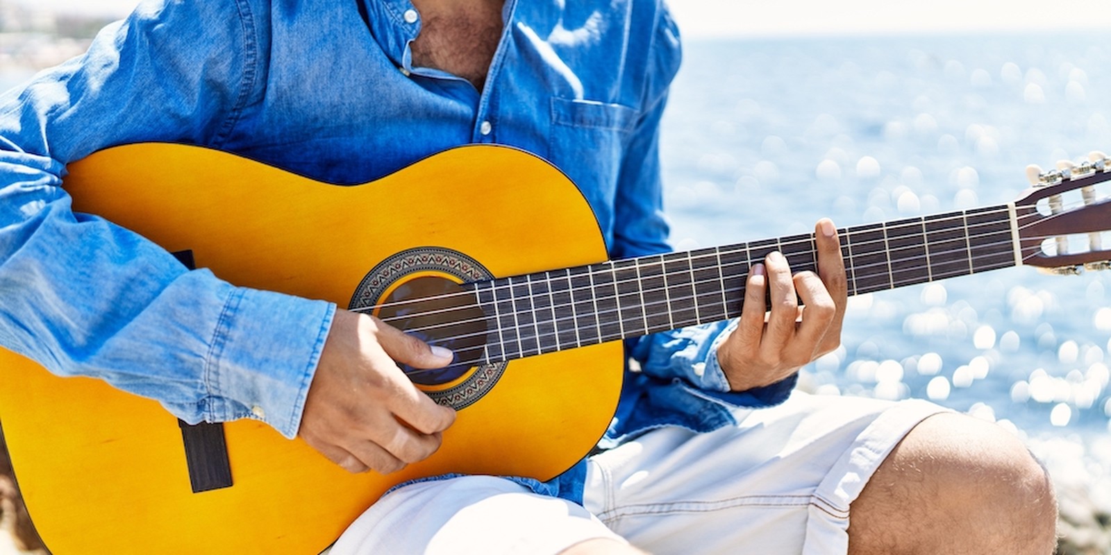 Chitarrista con chitarra classica in spiaggia