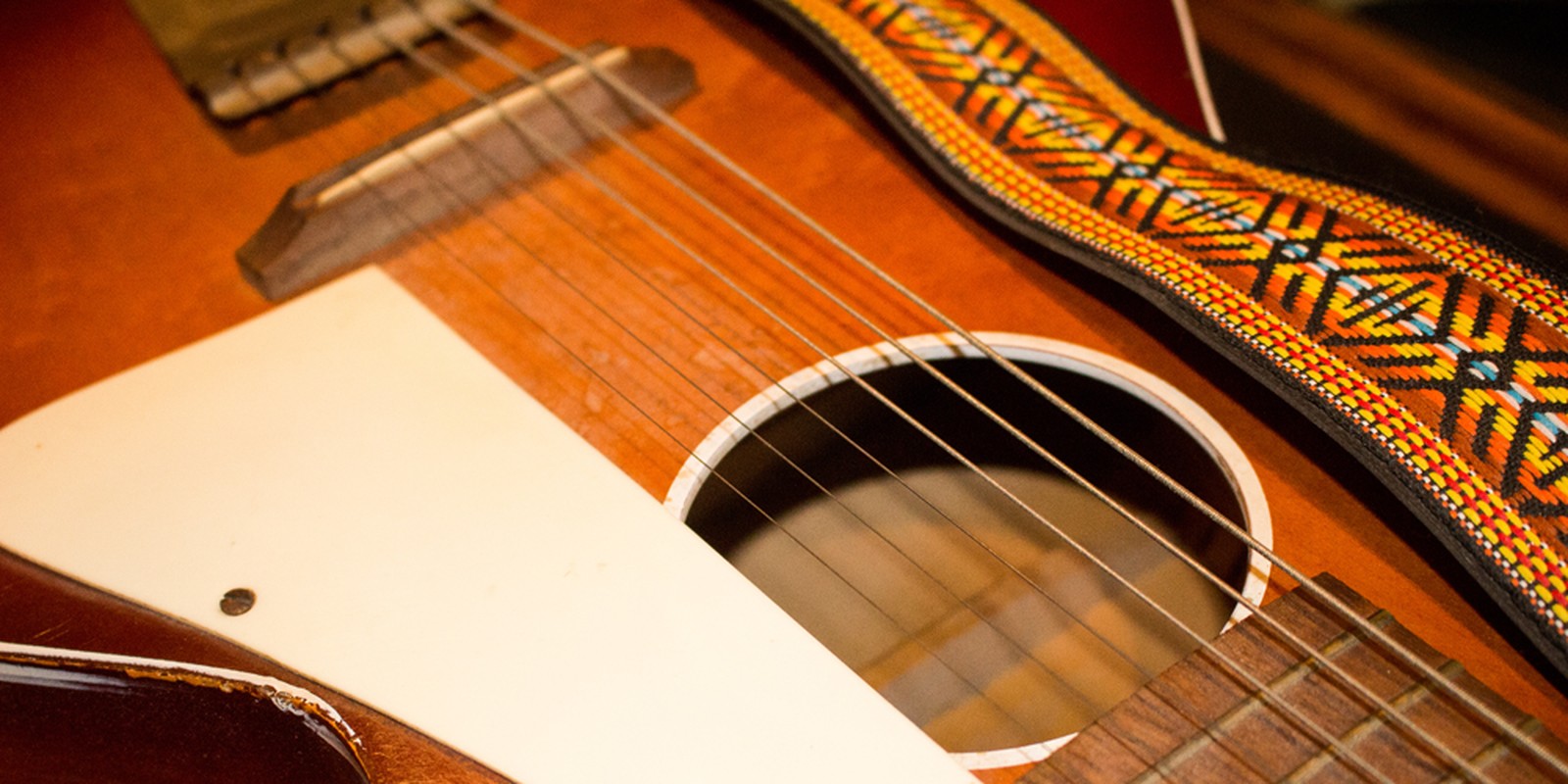 Akustikgitarre mit gemustertem Gurt