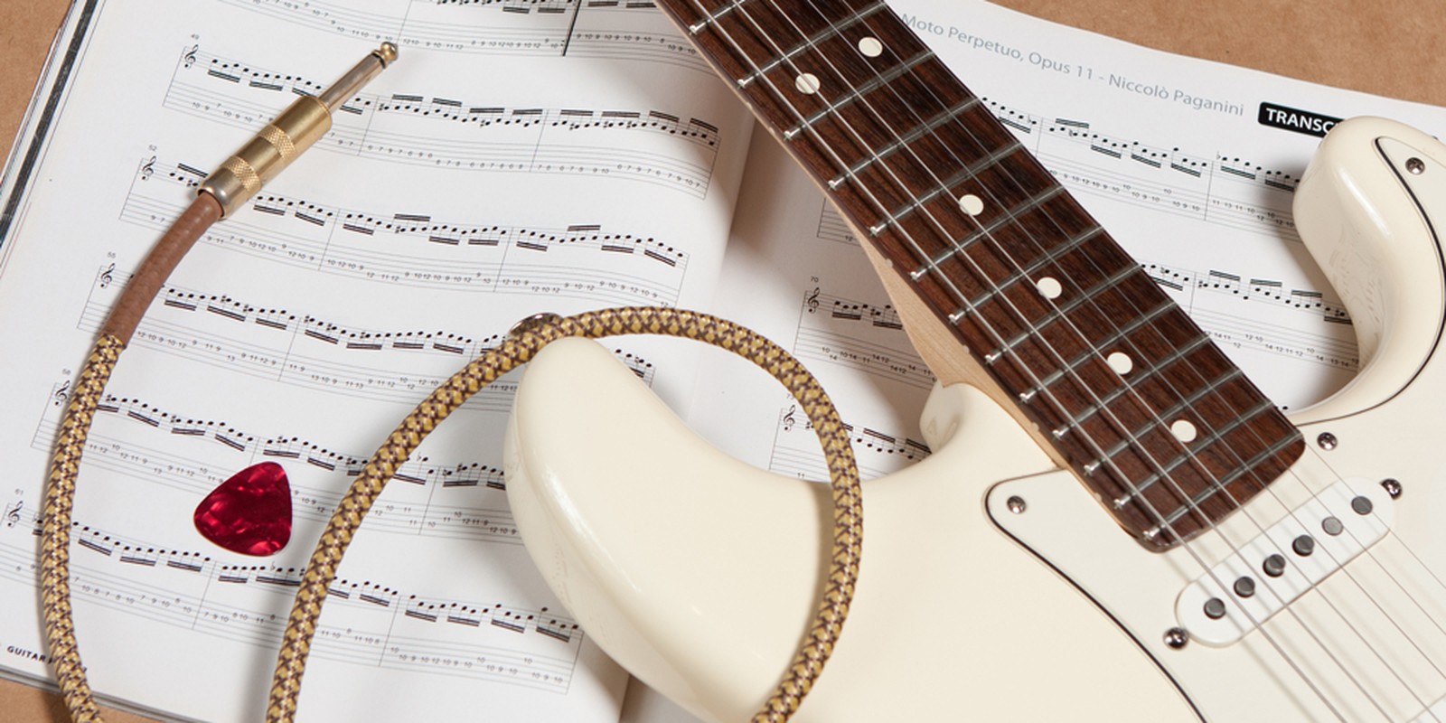 Hals einer E-Gitarre auf Notenpapier