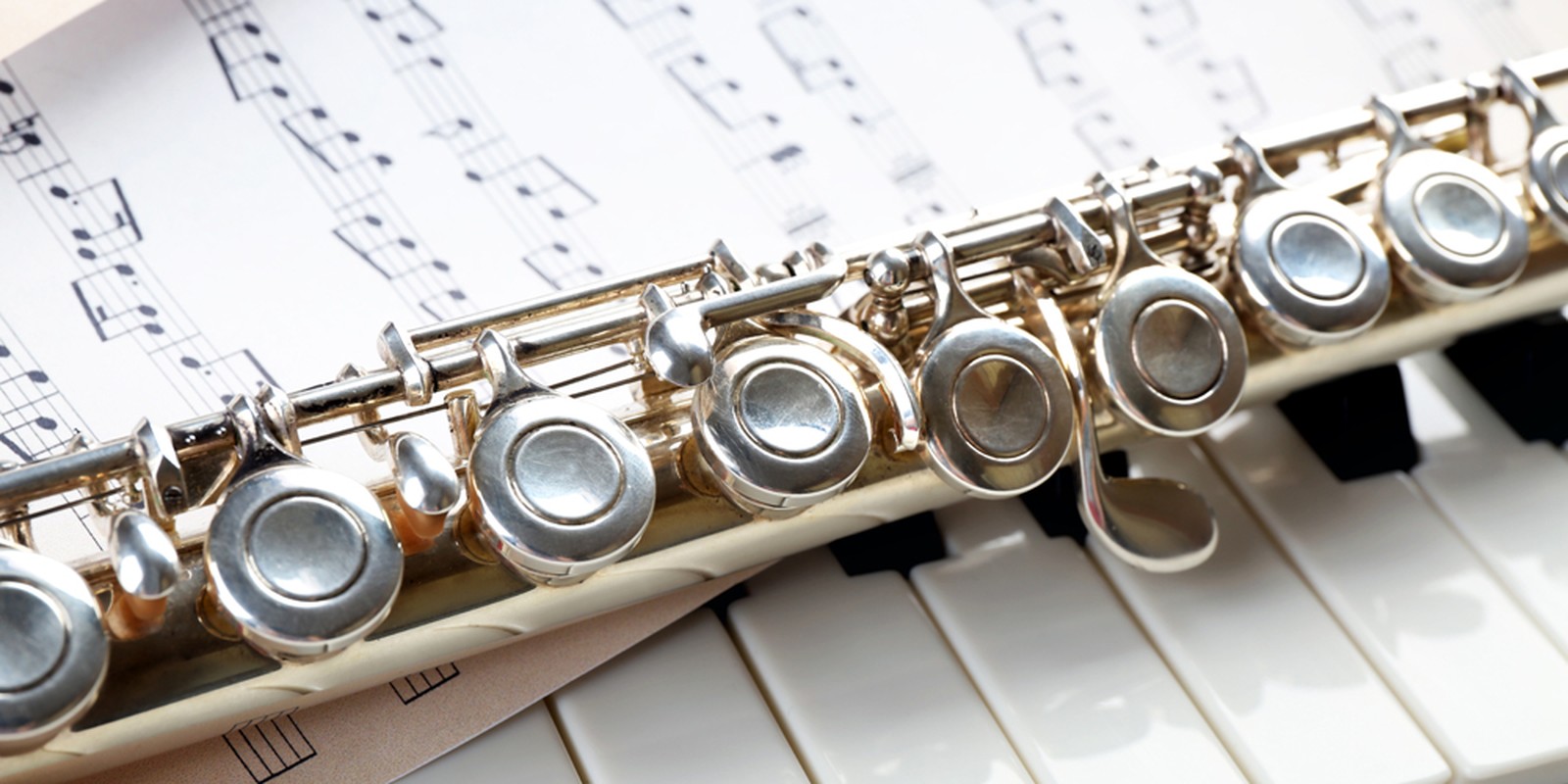 Querflöte mit geschlossenen Klappen auf Notenpapier