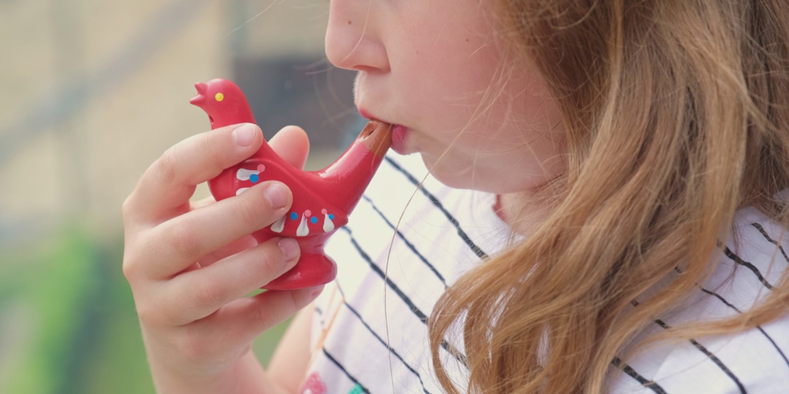 Mädchen spielt eine Vogelpfeife