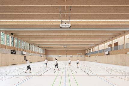 "Schülerinnen und Schüler spielen Volleyball in einer neuen Sporthalle."