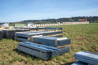 Gestapeltes Montagematerial für die Agri-PV Anlage in Darast auf einer grünen Freifläche – Vorbereitung für den Bau durch Geiger Energietechnik.