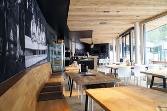 Modernisierter Restaurantbereich der Erdinger Sportalp in Oberstdorf mit stillvoller Einrichtung, Tischen und warmen Licht.