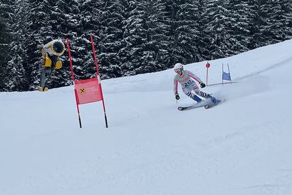 Athlet im Geiger-Rennanzug in rasanter Kurvenlage während des Slalomrennens beim Geiger Cup 2025, mit Schneekanone und Walser-Raiffeisen-Tor im Hintergrund