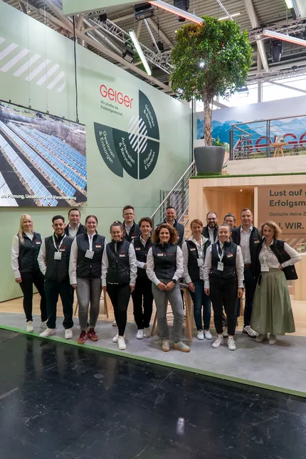 Eine Gruppe von Mitarbeitenden der Geiger Gruppe vor dem Messestand auf der IFAT in München.