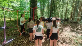Eine Gruppe an Auszubildenden bei einem Teambuilding Spiel im Wald.