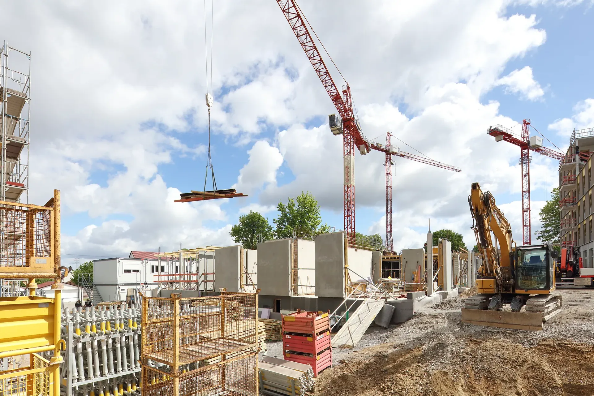 Ein Kran hebt Materialien für den weiteren Ausbauauf der Baustelle an einen neuen Platz.