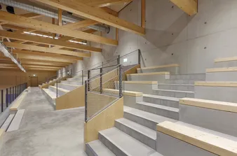 Zuschauertribüne in der neuen Sporthalle in Senden mit hellen Holzelementen.