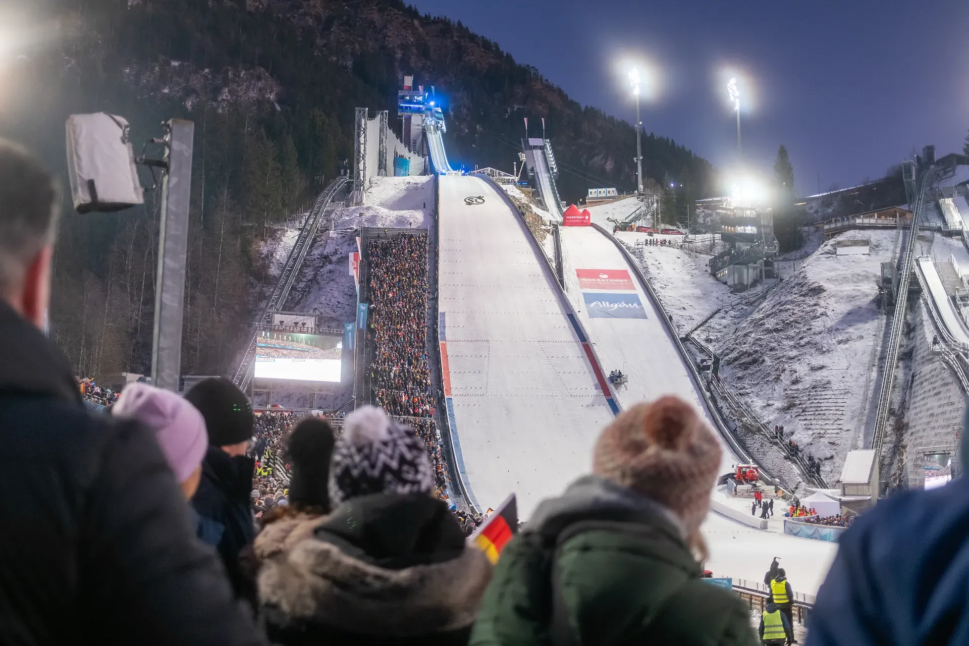 Skisprungschanze in Oberstdorf mit Flutlicht und Fans