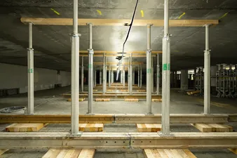 Stützen, welche während den Umbaumaßnahmen einer Tiefgarage die Decke halten. In der Mitte eine Art Lichttunnel, welche für die Beleuchtung sorgt.