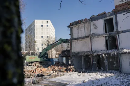 Bagger vor einem Gebäude beim Abbruch