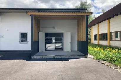 Eine zweiflügelige Tür, welche geöffnet ist und Eintritt zu einer Schlachterei gewährt.