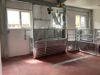 Eine Halle mit rotem Boden und verschieden glänzende Metallgerüsten.