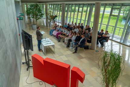 "Einer der Geschäftsführer der Geiger Gruppe hält eine Rede vor einer Gruppe Schulabsolventen."