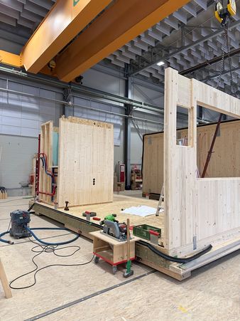 Einbau der Wände eines Holzmodulbaus in der Fertigung bei Geiger Holzsystembau Wangen.